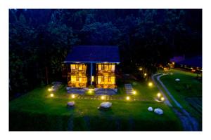 una pequeña casa con luces en el patio por la noche en Vayal Veedu - Luxury Farm Villas by the woods, en Muthanga