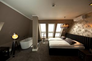 Schlafzimmer mit einem Bett und einer Badewanne in der Unterkunft Boutique-Hotel GEORGES in Essen