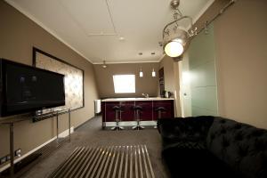 a living room with a couch and a flat screen tv at Boutique-Hotel GEORGES in Essen