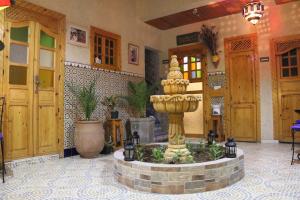 a lobby with a fountain in the middle of a room at Riad Les Chtis D'Agadir in Agadir