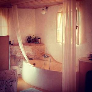 a bath tub in a room with a window at Hamitzpa- Desert Hosting in Ezuz in ‘Ezuz