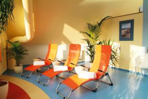 un grupo de sillas naranjas en una sala de espera en Alte Schleiferei, en Breitenbrunn