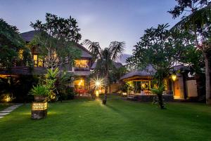 a house with a lawn in front of it at Manzelejepun Villa & Pavilion in Sanur