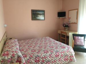 1 dormitorio con cama, mesa y escritorio en Hotel Marnie, en Massarosa