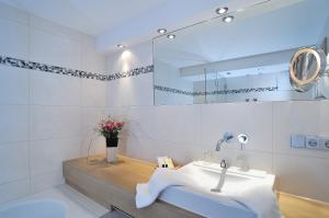 a bathroom with a sink and a mirror at Landhotel Böld Oberammergau in Oberammergau