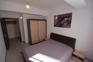 - une chambre avec un lit et une porte en bois dans l'établissement Rya Home 1, à Bucarest