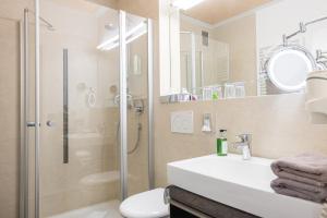 a bathroom with a shower and a sink and a toilet at Landhotel Böld Oberammergau in Oberammergau