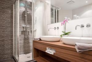 a bathroom with two sinks and a shower at Landhotel Böld Oberammergau in Oberammergau