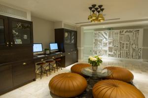 a living room with a table and some stools at The Ampersand Hotel - Small Luxury Hotels of the World in London