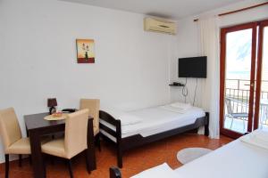 a small room with a bed and a table and a television at Apartment Lima in Kotor