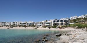 una spiaggia di fronte a un grande edificio di Speelhuis Studios a Langebaan