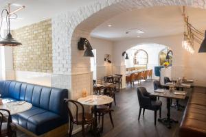 a restaurant with a blue couch and tables and chairs at The Ampersand Hotel - Small Luxury Hotels of the World in London