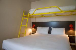 um quarto com uma cama e um beliche em The Originals Access, Hôtel Limoges Nord em Limoges