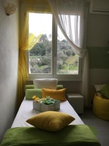 een bed in een kamer met een raam en kussens bij VerdeLimone in Monterosso al Mare