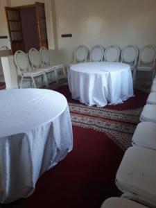 a room with two tables and chairs with white table cloth at Oasispalmares in Er Rachidia +62 photos