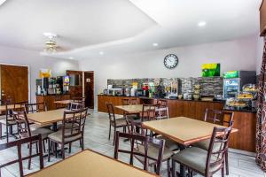 a restaurant with tables and chairs and a clock on the wall at Quality Inn & Suites Orangeburg in Orangeburg
