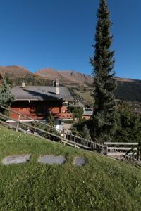 una casa en una colina con una valla y un árbol en Altiplano 003 en Verbier