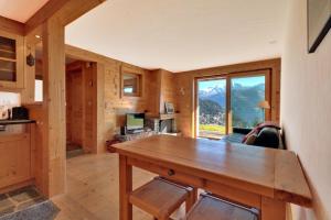 Cabaña de madera con cocina y sala de estar. en Altiplano 003 en Verbier