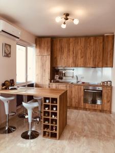 a kitchen with wooden cabinets and a table with wine bottles at Molly's Suite in Sofia