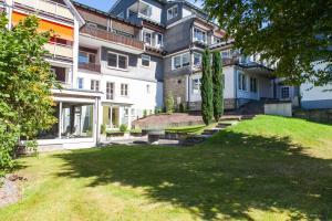 an exterior view of a large building with a yard at Hotel Störmann in Schmallenberg