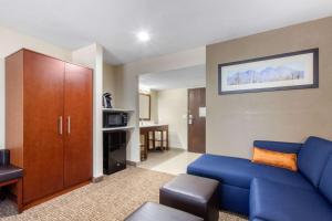 a living room with a blue couch and a cabinet at Comfort Inn & Suites Pinetop Show Low in Pinetop-Lakeside