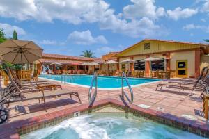 a pool with chairs and umbrellas at a hotel at Inn Marin and Suites, Ascend Hotel Collection in Novato