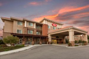 ein Hotelgebäude mit Sonnenuntergang im Hintergrund in der Unterkunft The Oaks Hotel & Suites in Paso Robles