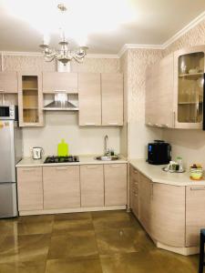 een keuken met houten kasten en een kroonluchter bij Apartment Kutuzoff Metro Kievskaya in Moskou