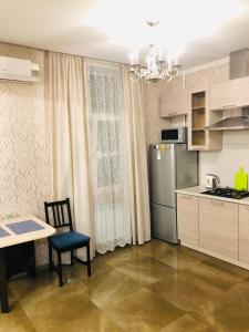 a small kitchen with a table and a refrigerator at Apartment Kutuzoff Metro Kievskaya in Moscow