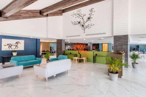 a lobby with blue and green furniture and plants at Quality Inn & Conference Centre in Orillia +32 photos
