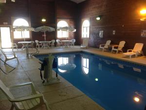 Kings Inn Cody في كودي: مسبح مع كراسي وطاولات وكراسي