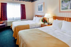 a hotel room with two beds and a window at Clarion Suites Anchorage Downtown in Anchorage