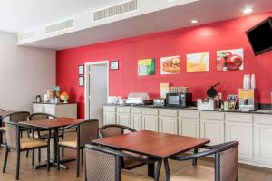 a kitchen with a table, chairs and a refrigerator at Quality Inn Downtown Historic District in Mobile
