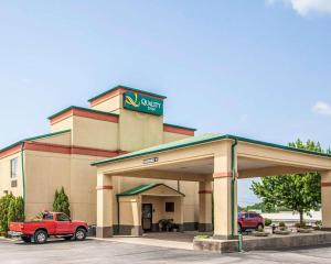 Quality Inn Florence Muscle Shoals في فلورنسا: وكالة سيارات مع شاحنة حمراء متوقفة في الأمام