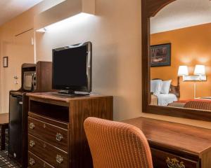 a room with a desk with a tv and a bedroom at Econo Lodge Eufaula in Eufaula