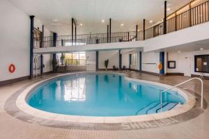 a large swimming pool in a building with a staircase at Quality Inn & Conference Centre in Orillia
