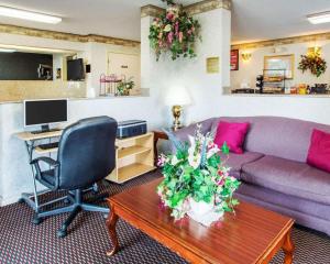 a living room with a purple couch and a desk at Econo Lodge Troy in Troy