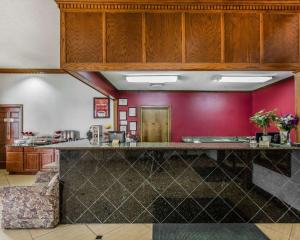 Econo Lodge Inn & Suites Enterprise في انتربرايز: مطبخ مع كونتر وجدار احمر