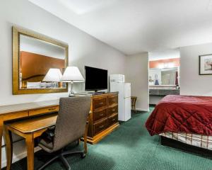 エンタープライズにあるEcono Lodge Inn & Suites Enterpriseのデスクとベッドが備わるホテルルームです。