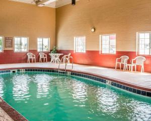 ein Swimmingpool mit Stühlen und Tischen in einem Gebäude in der Unterkunft Comfort Inn Decatur Priceville in Decatur