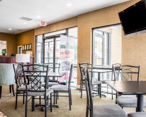 a restaurant with tables and chairs and a flat screen tv at Quality Inn in Madison