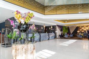 a lobby with a table with flowers on it at Swissotel Sarajevo in Sarajevo