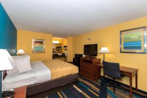 um quarto de hotel com uma cama, uma secretária e uma televisão em Quality Inn Albertville US 431 em Albertville