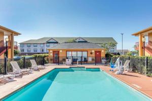 een zwembad met stoelen en een huis bij Quality Inn Bessemer I-20 exit 108 in Bessemer