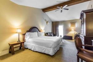 - une chambre avec un grand lit blanc et une chaise dans l'établissement Inn at the Mill, Ascend Hotel Collection, à Fayetteville