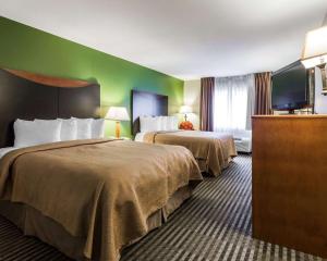 a hotel room with two beds and a flat screen tv at Quality Inn & Suites Birmingham - Highway 280 in Birmingham