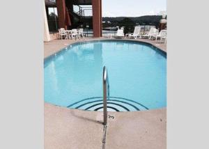 una gran piscina azul con sillas y mesas. en Quality Inn & Suites Clarksville, en Clarksville