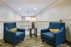 2 sillas azules en una habitación con mesa en Quality Suites Springdale West I-49, en Springdale