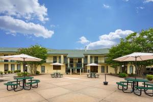 a courtyard with picnic tables and umbrellas in front of a building at Quality Inn & Conference Center in Heber Springs