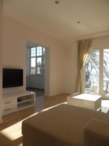 a living room with a bed and a television at Apartments Tri Palme in Baška Voda